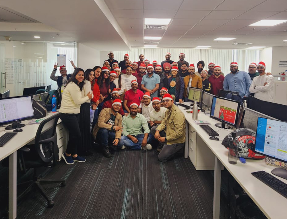 Team members exchanging gifts and spreading holiday cheer in the workplace.